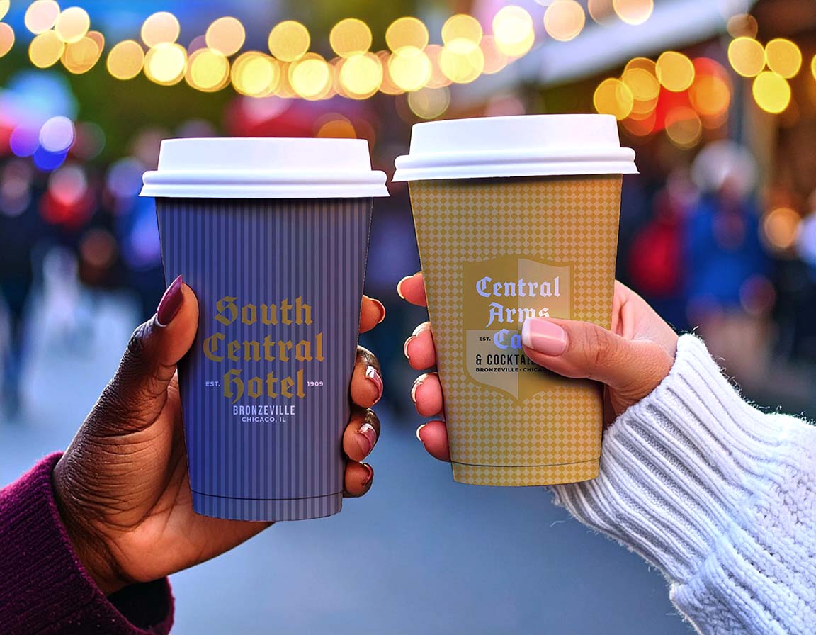 Two hands holding branded paper coffee cups in an outdoor nighttime setting with blurred lights in the background. The left cup is dark blue with gold text reading 'South Central Hotel' and 'Nashville, TN', and the right cup is tan with a gingham pattern and white text reading 'Central Arma Cafe' and 'S.