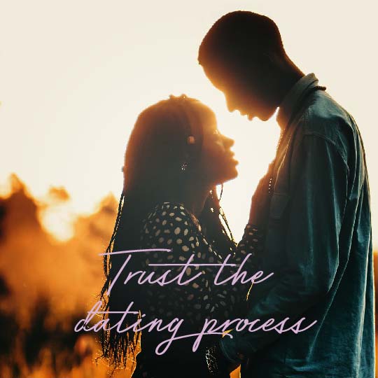A romantic silhouette photo of a couple embracing at sunset with the overlaid text 'Trust the dating process' in purple script.